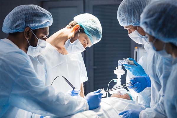 A team of doctors performing surgery on a patient in a hospital operating room.