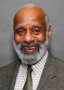 Profile picture of Haynes, with grey beard, smiling.