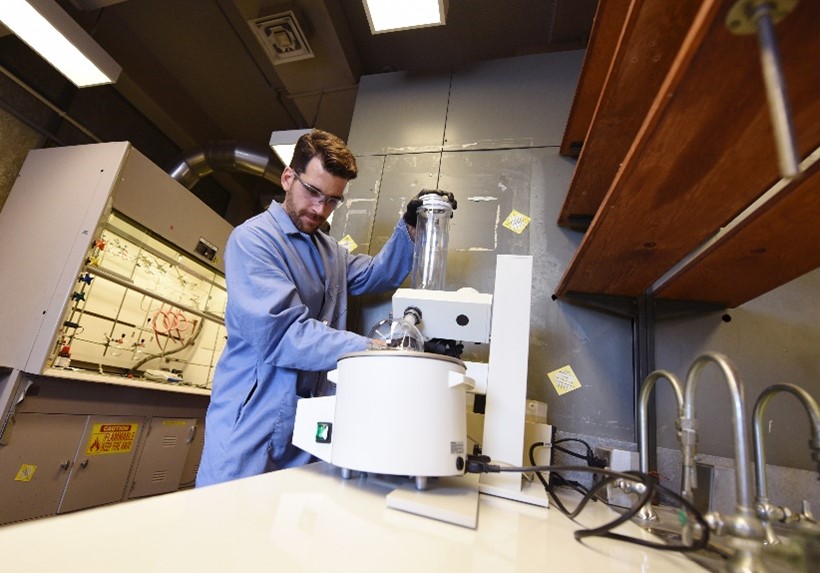 Dr. Leibfarth working at a large instrument with a glass cylinder and sphere.