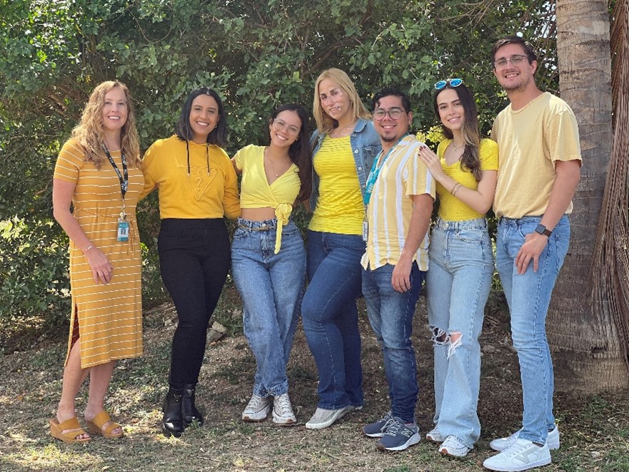 Dr. Appleyard with six other individuals standing in a row outside in front of trees.